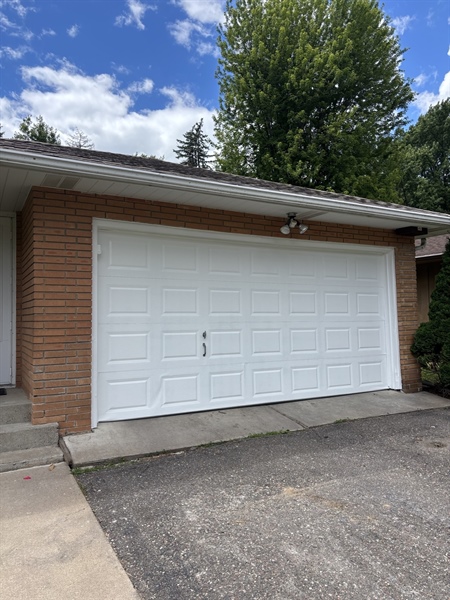 Freshly painted white metal garage door after refinishing project in Crystal, MN