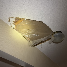 Water-damaged popcorn ceiling opening before one-day drywall repair in Chaska, MN