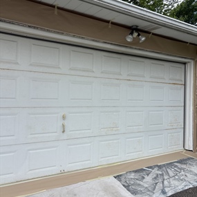 Worn and rust-stained metal garage door before sanding and painting in Crystal, MN