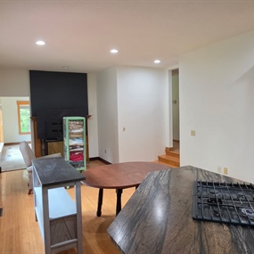 Open kitchen and living area with newly painted walls and black fireplace accent wall