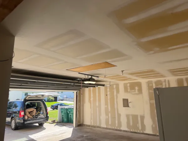 New garage ceiling drywall taped and mudded around the attic access opening