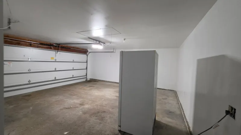 Finished garage ceiling with new attic access panel and painted side wall in Apple Valley