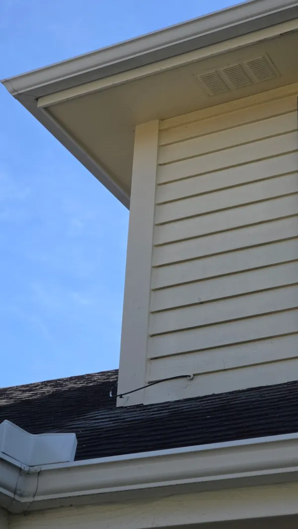 Replacement corner trim painted to match the siding below the roofline
