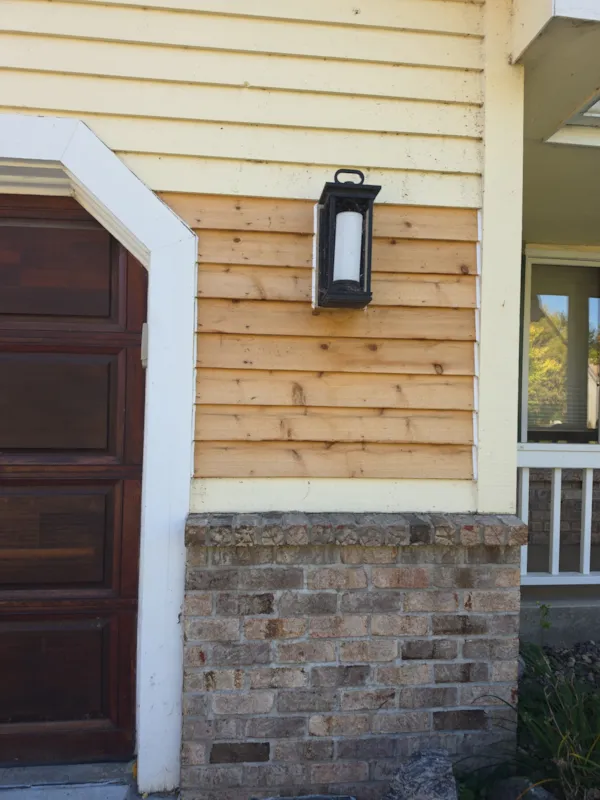 New unpainted cedar lap siding installed beside the garage door of a Burnsville home