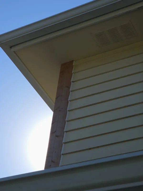 New unpainted wood corner trim installed below the roof eave of a Burnsville home