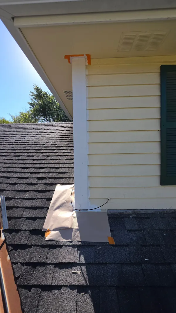 Primed corner trim with the shingle roof masked off during siding repair in Burnsville